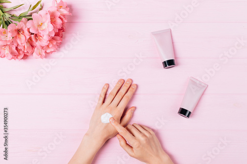 Flat lay female s hands apply cosmetic skin care cream