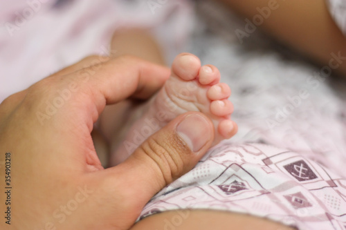 Close up of new born baby feet in parents hand. Concept for love,happy family and parenthood.