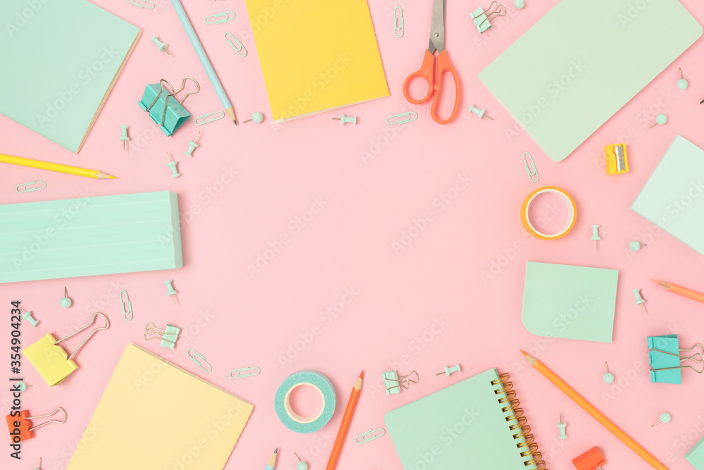 Border frame made of office supplies on a pink pastel background. Back to school concept with place for text. Border frame made of office supplies on a pink pastel background. Back to school concept with place for text.