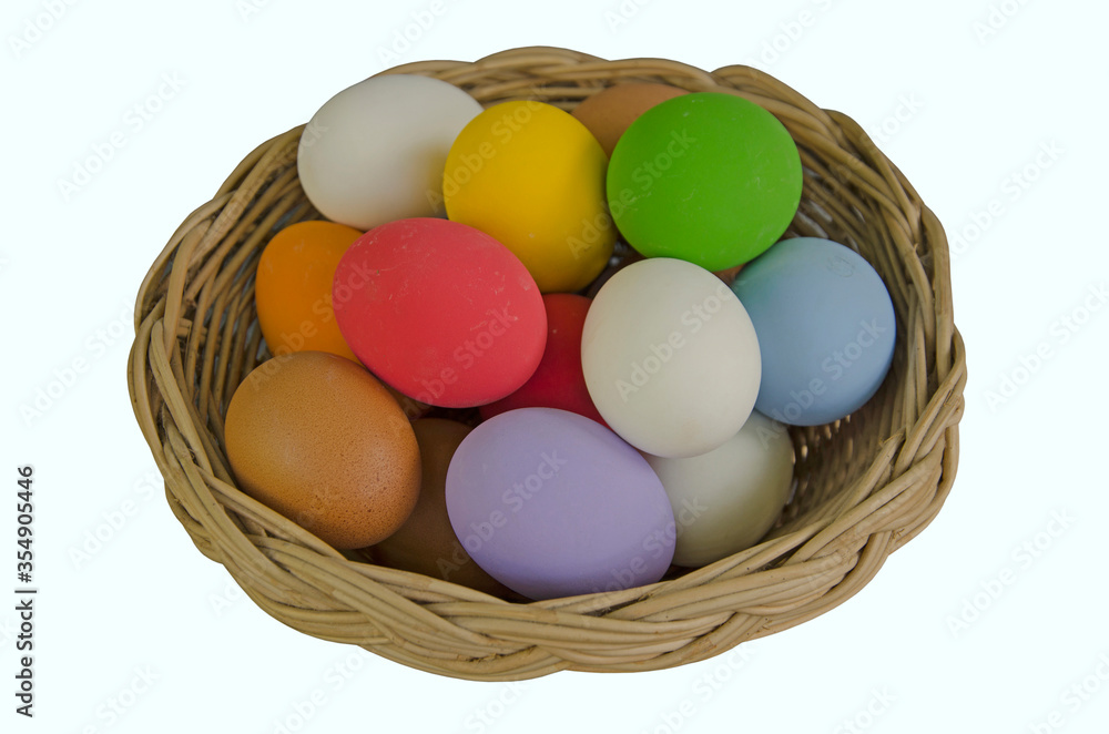 Woven rattan basket of colored eggs on white background