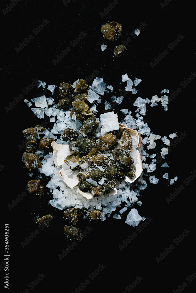 Heap of Salted capers and sea salt crystals Heap of Salted capers and sea salt crystals
