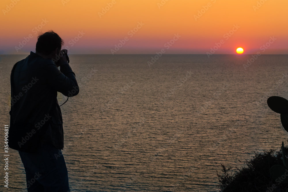 Man photographs a beautiful sunset in Italy.