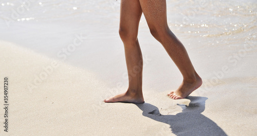 Female legs on sand texture.