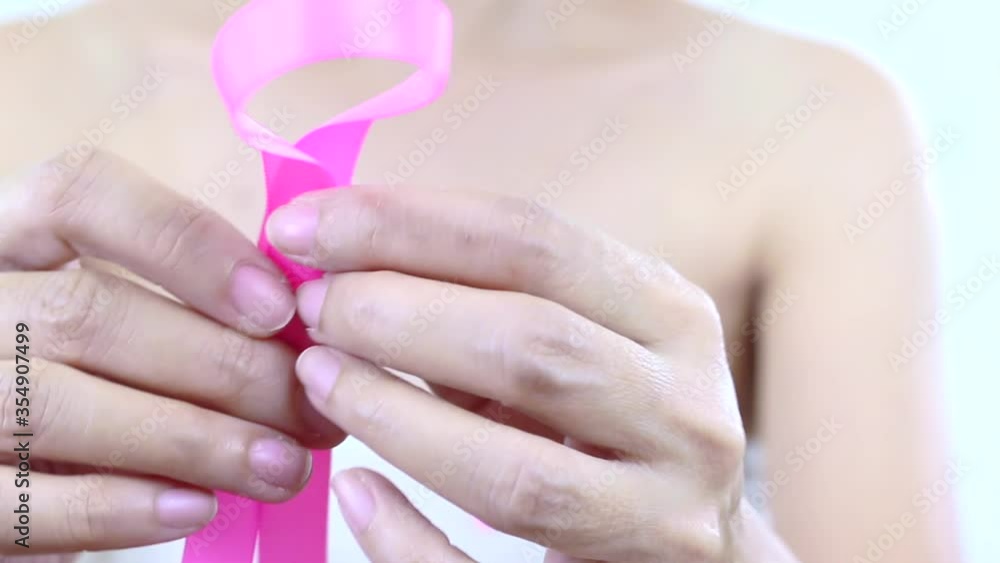 Pink ribbon with  a breast cancer woman - A breast cancer survivor woman making a pink ribbon. Breast cancer surgery scars by partial mastectomy. Cancer awareness concept.