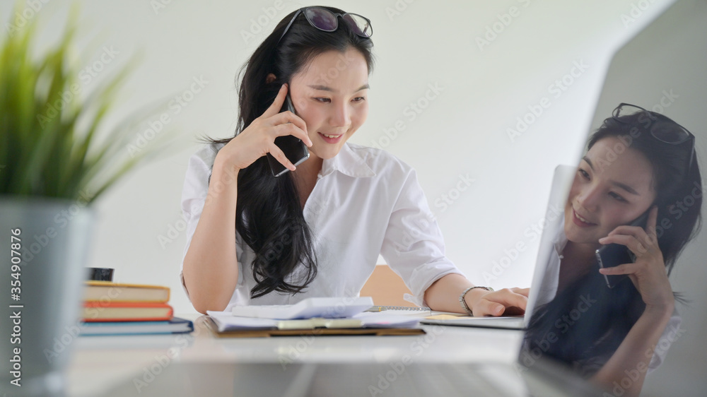 A smiling young woman using a smartphone to make business contacts A smiling young woman using a smartphone to make business contacts