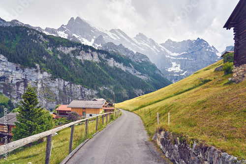 Road between mountain villages Mürren and Gimmelwald. Swiss Alps landscape photo with nature and snowy mountains taken above Lauterbrunnen valley, Switzerland. 