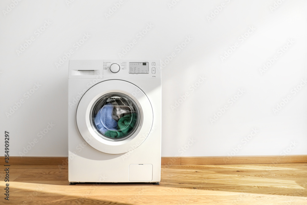 Working washing machine on white background - obrazy, fototapety, plakaty 