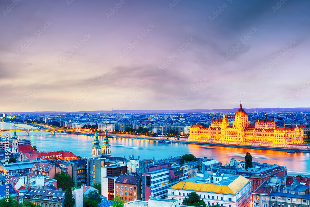 Naklejka premium Budapest panorama with parliament and bridge during blue hour sunset.