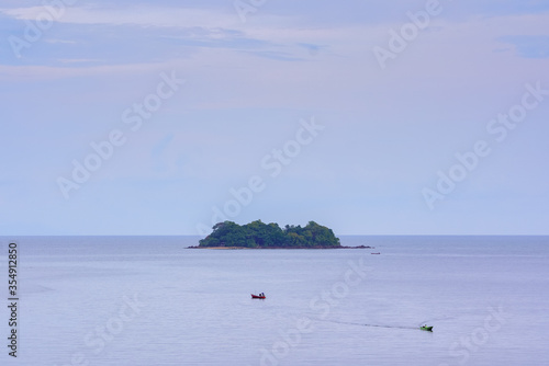 Small boat and island in tropical sea 