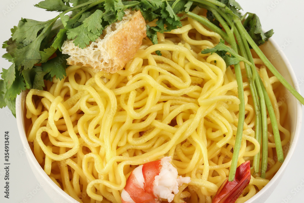 Fresh yellow egg noodle prawn tofu coriander leaf in bowl on whit background Fresh yellow egg noodle prawn tofu coriander leaf in bowl on whit background