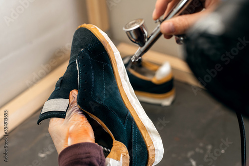 Fotografía Craft man painting on a pair of shoes
