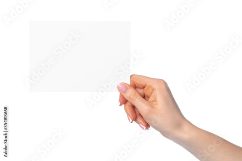 Woman's hand holding blank white sheet of paper isolated on white