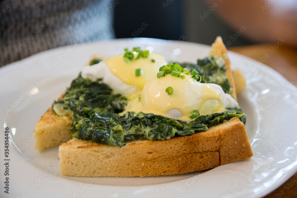 Traditional Eggs Benedict Florentine with poached eggs. creamed spinach, green onions, Hollandaise sauce and nutmeg, over a brioch bread Traditional Eggs Benedict Florentine with poached eggs. creamed spinach, green onions, Hollandaise sauce and nutmeg, over a brioch bread