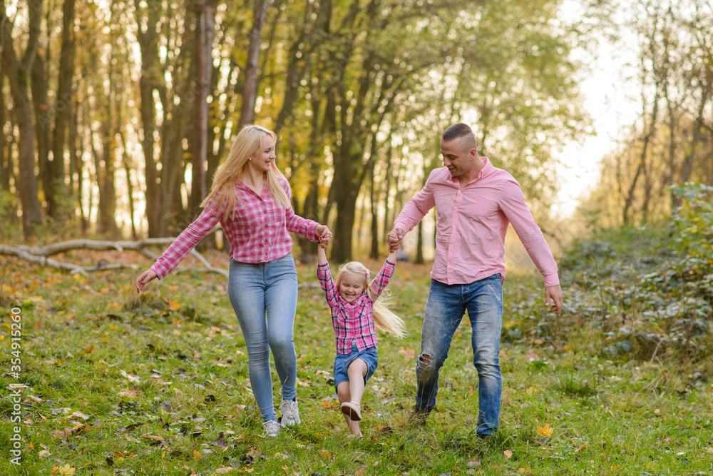 Fototapeta premium Father, daughter and mother walking outdoors. Happy family.