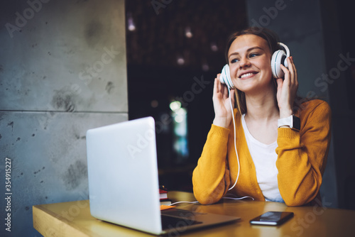 Young woman updating playlist on media application 