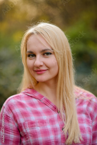 Close-up portrait of a blonde woman in a pink shirt.