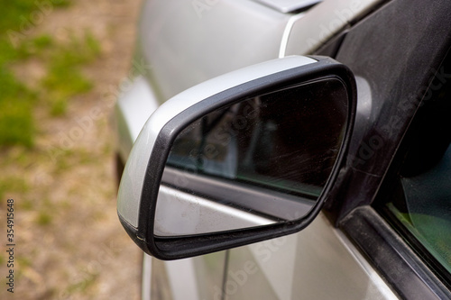 Close-up of side view mirror on silver car.
