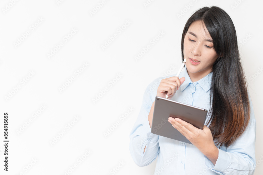 asian women read and thinking work new idea on tablet and holding pen. tecnology working concept. asian women read and thinking work new idea on tablet and holding pen. tecnology working concept.