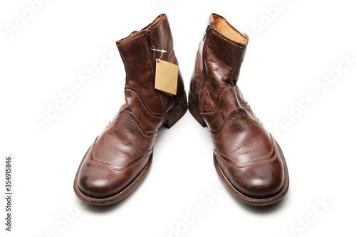 Two brown shoes with untied laces on a white isolated background