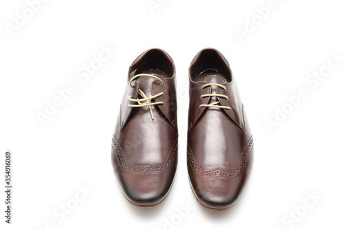 Two brown shoes with untied laces on a white isolated background