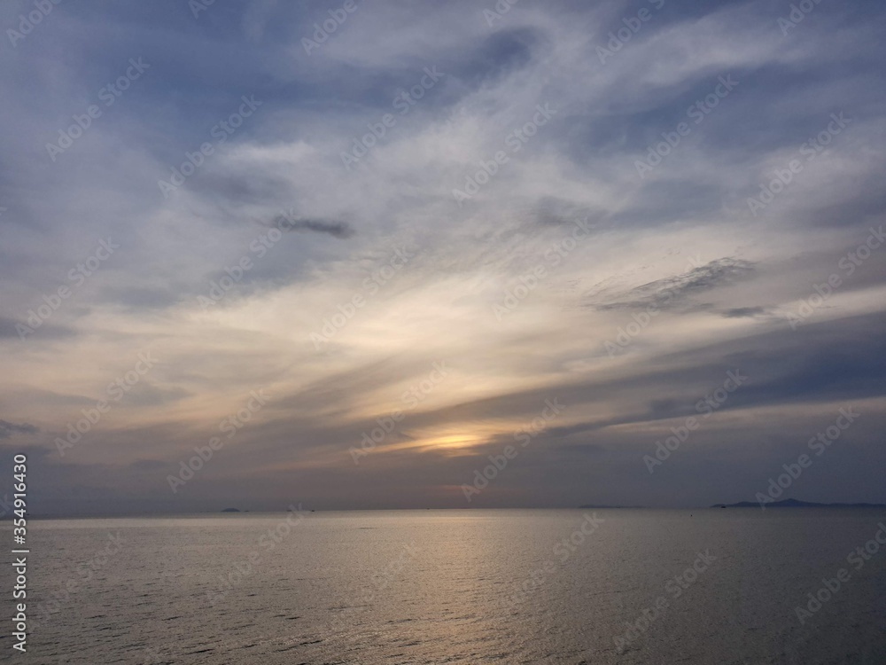 Sunset in evening at the sea with cloudy and blue sky in background in Thailand