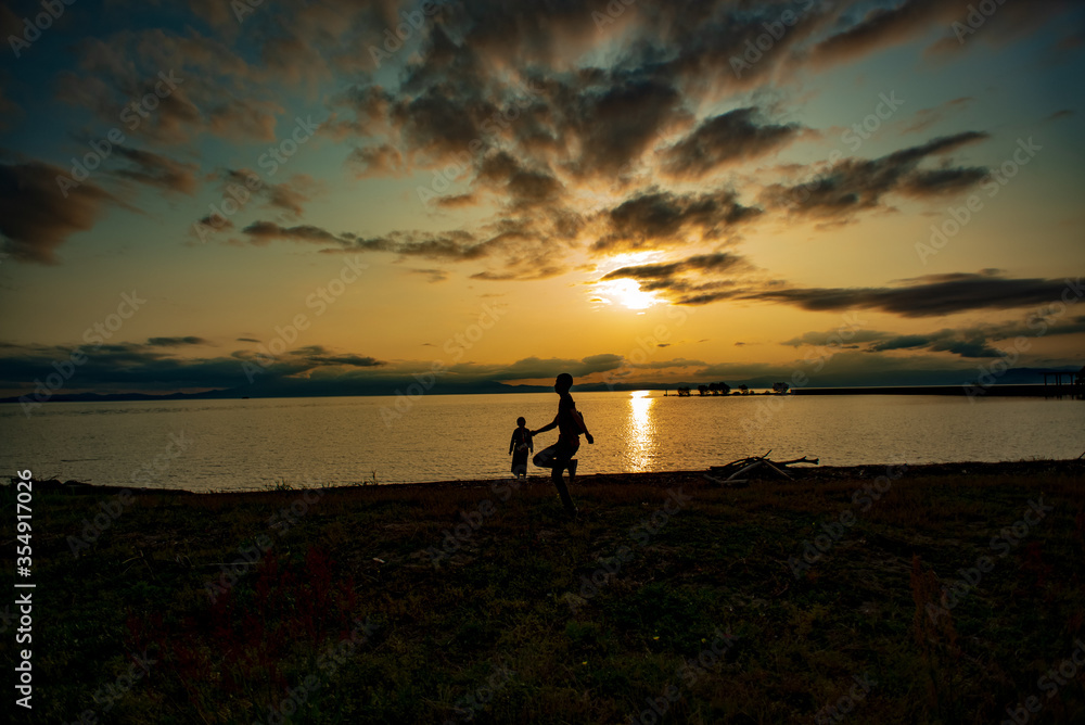 Sunset of the lake of Biwa and silhouette of Children in Japan.