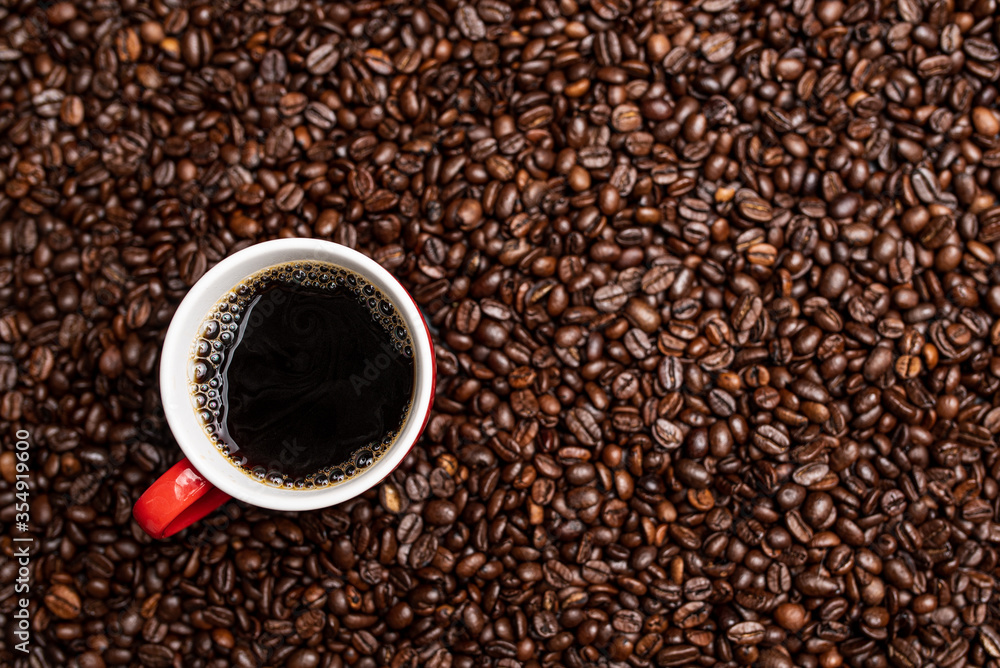 Cup of black coffee from the top on background covered with coffee beans. Cup of black coffee from the top on background covered with coffee beans.