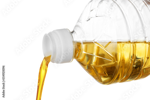 Pouring oil for cooking in a bottle isolated on white background.