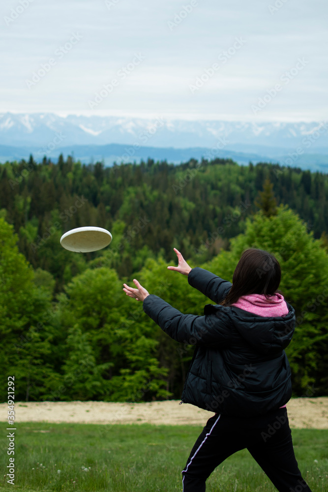 The happy girl smiles. Beautiful landscape. A girl plays frisbee in nature. Girl catches a frisbee. The happy girl smiles. Beautiful landscape. A girl plays frisbee in nature. Girl catches a frisbee.