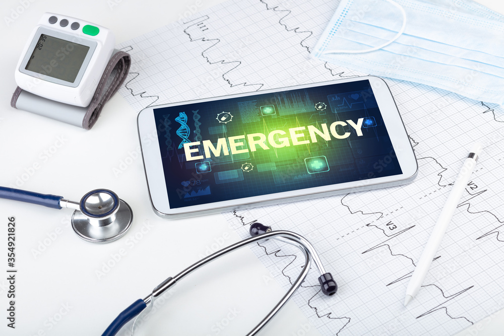 Tablet pc and medical stuff with EMERGENCY inscription, prevention concept Tablet pc and medical stuff with EMERGENCY inscription, prevention concept