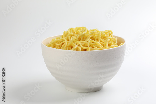 Fresh yellow egg noodle in bowl on whit background