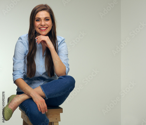 Smiling woman sits with crossed legs