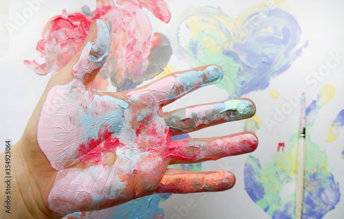 the imprint of a human hand with colorful paint and paint on the hand