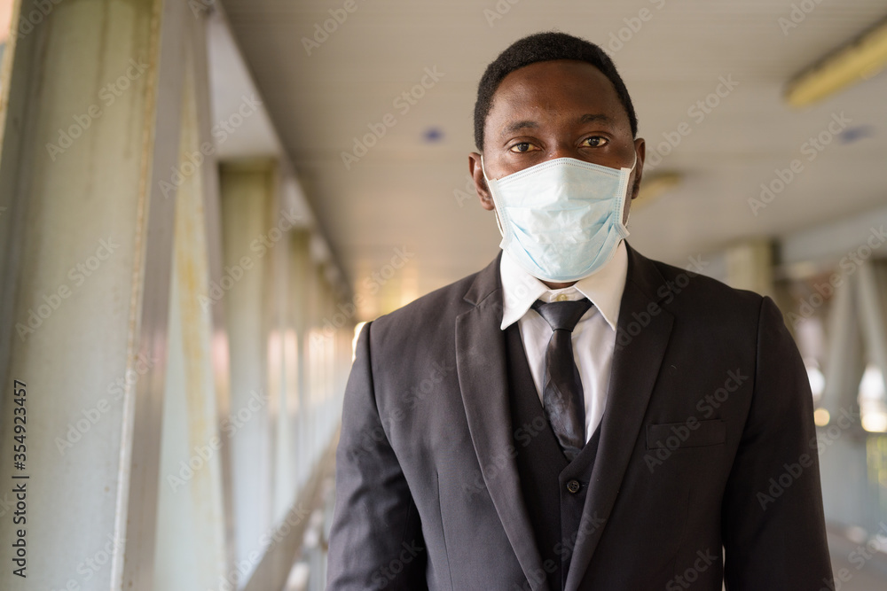 Face of African businessman wearing mask at the footbridge