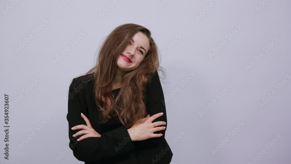 Young Attractive Woman Brunette In In A Black T-Shirt, Sweater On White Background, Cute Female Holds Hands Near Her Head. The Concept Of People's Tenderness, Kindness And Generosity. Young Attractive Woman Brunette In In A Black T-Shirt, Sweater On White Background, Cute Female Holds Hands Near Her Head. The Concept Of People's Tenderness, Kindness And Generosity.