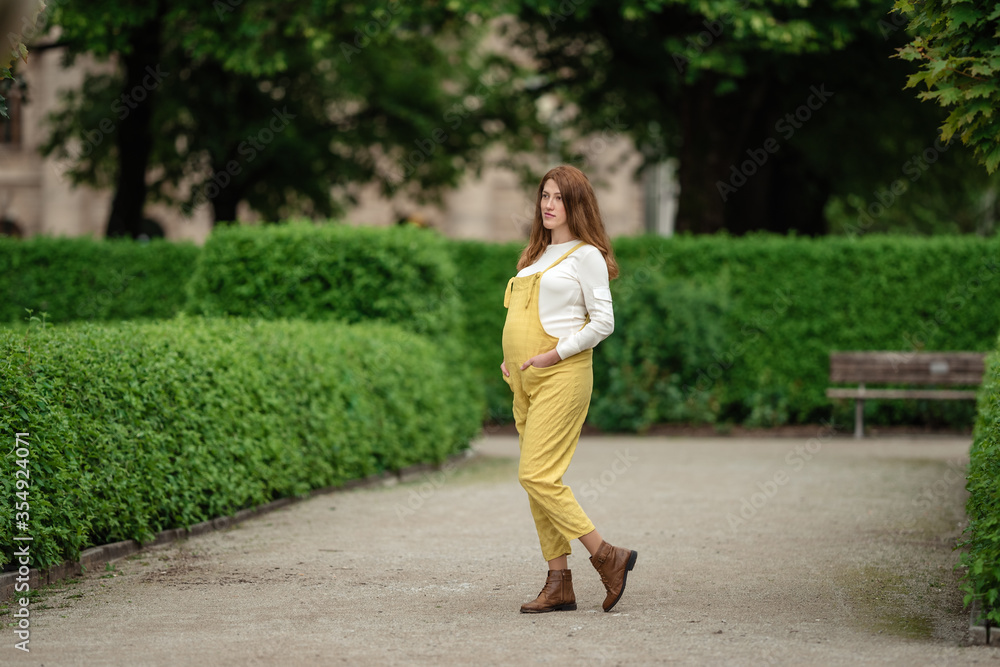 Beautiful pregnant girl walking in the Park.