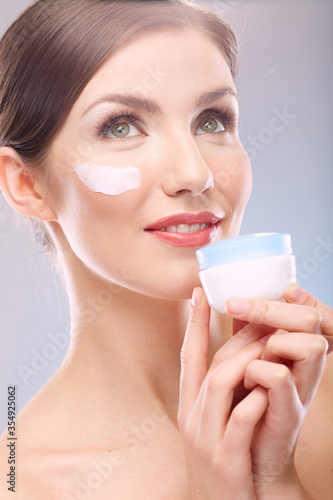 close up beauty portrait of smiling woman holding jar cream.