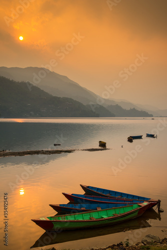 Reflection of boats in Phewa Lake in the evening before sunset, Phokhara, Nepal. photo