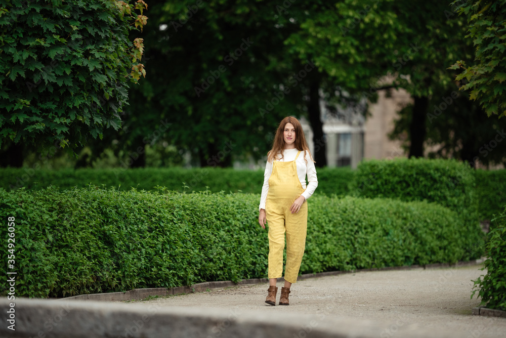Beautiful pregnant girl walking in the Park. Beautiful pregnant girl walking in the Park.