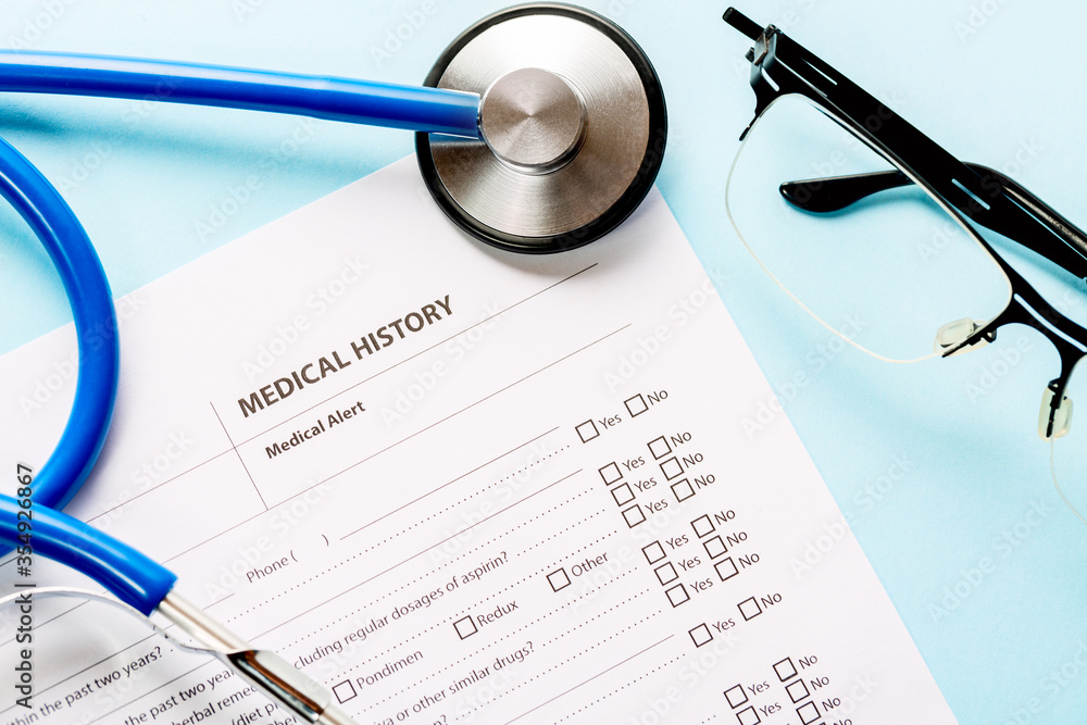Medical and healthcare concept. Close up image of a medical history form and doctors stethoscope with glasses. Medical and healthcare concept. Close up image of a medical history form and doctors stethoscope with glasses.