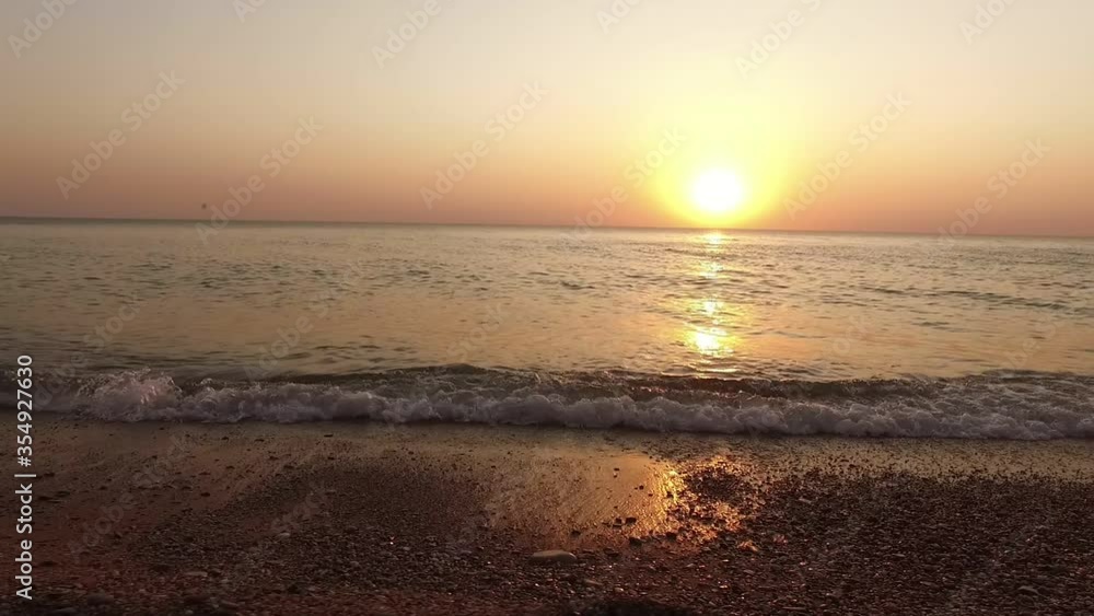 Free flight low over the calm ocean waves against the background of the evening sun, going below the horizon Free flight low over the calm ocean waves against the background of the evening sun, going below the horizon