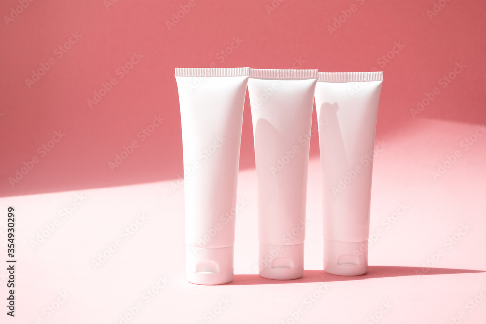 Three moisturizer creams containers on cute pink background. Beauty product mockup with trendy shadow. Concept delicate, lightness and pure skincare Three moisturizer creams containers on cute pink background. Beauty product mockup with trendy shadow. Concept delicate, lightness and pure skincare