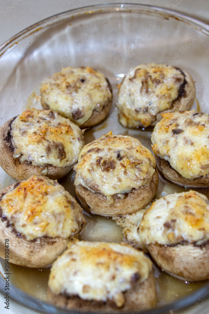 Stuffed mushrooms stuffed with cheese, mushroom stalks and onions. In a baking dish.