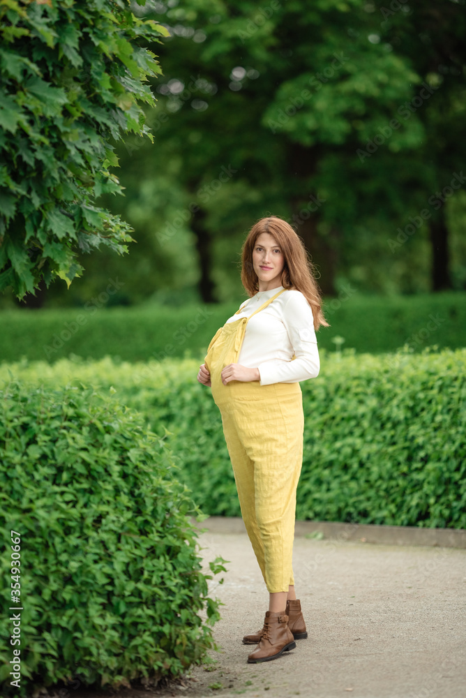 Fototapeta premium Beautiful pregnant girl walking in the Park.