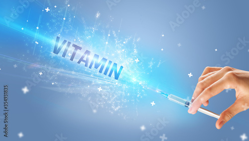 Syringe, medical injection in hand with VITAMIN inscription, medical antidote concept
