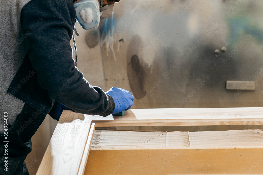 Carpenter is painting a wood with lacquer. Carpenter is painting a wood with lacquer.