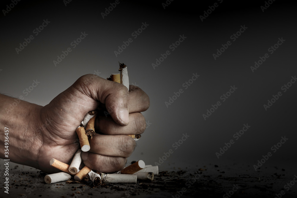 Hand fist smash or punch on cigarette.Cigarettes is addictive to be