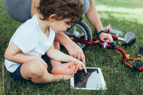 Mother teaching her son how to use a digital tablet.
