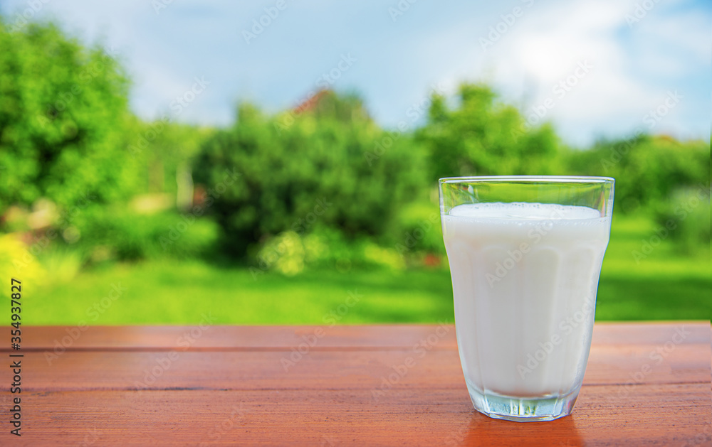 A glass of milk on the table in the garden . A glass of milk on the table in the garden .
