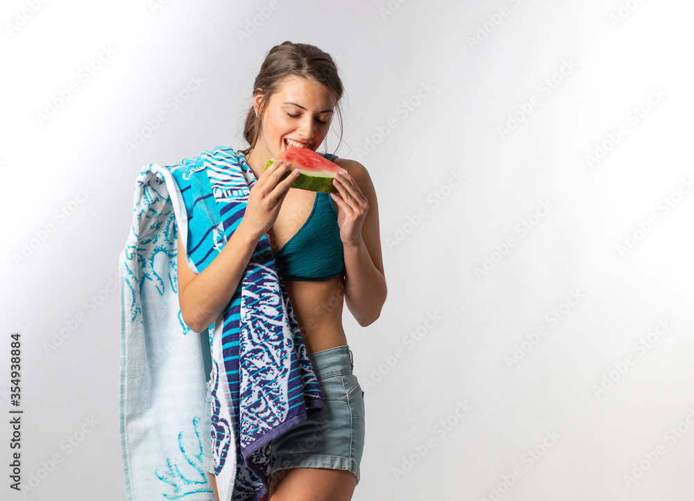 Young Model going to the beach eating watermelon on white background Young Model going to the beach eating watermelon on white background